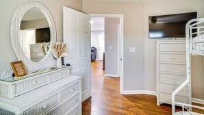A room with a white dresser, a large mirror, a television, and a bunk bed. - Home 14 Mi to Highpoint Health w/ Fenced Yard! (Hendersonville)