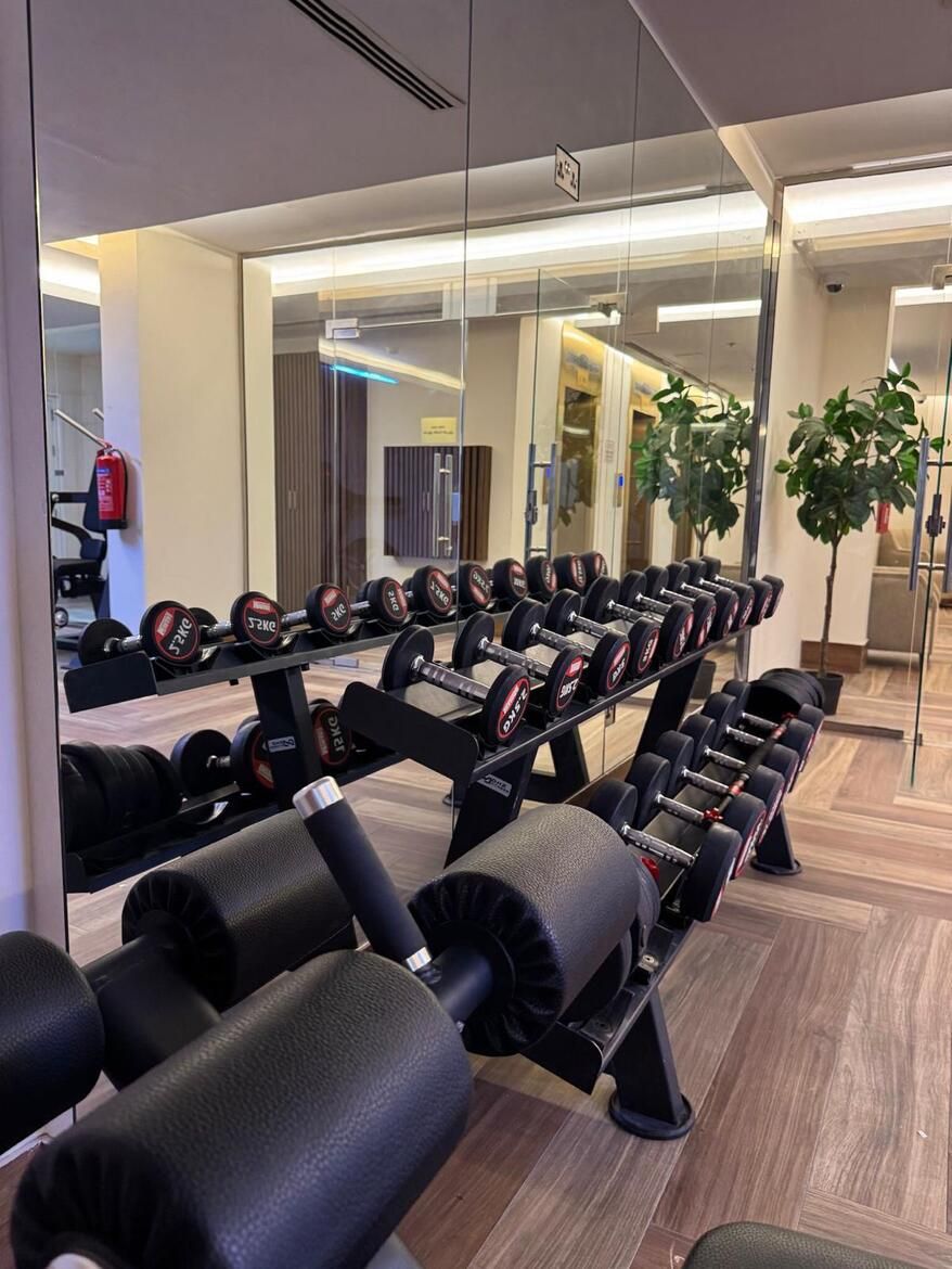 A gym with weightlifting equipment, including dumbbells and benches.