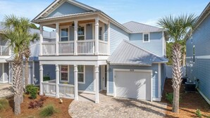 A two-story house with a balcony, a garage, and a driveway.