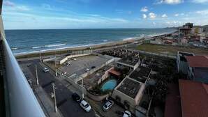 A coastal view with a beach, parking area, and buildings. - RN STUDIO - APTO 620 (Maceio)