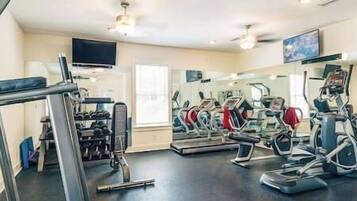 A gym with treadmills, elliptical machines, and weightlifting equipment.