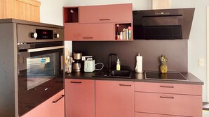 A modern kitchen with a built-in oven, a coffee maker, and a microwave. - The yellow house at the harbor (Wolgast)