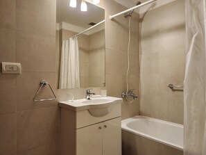 Enjoy a refreshing shower in the bathroom with a sink, separate shower area, and handheld showerhead.