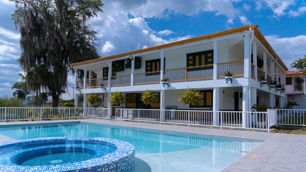 A two-story building with a swimming pool and a hot tub. - Colina del Sol Hotel Hacienda (Quimbaya)