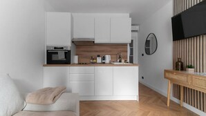A compact kitchen with white cabinets, a wooden countertop, and a built-in oven. - Le Serbie RdC - 4 rue de Serbie - Vichy (Vichy)