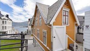 Ein zweistöckiges Haus mit steilem Dach, weißer Fassade und einer Tür mit weißem Rahmen.