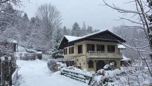 A two-story house with a balcony, surrounded by snow-covered trees and a snow-covered path leading to the entrance. - Au moulin - GEX - Gîte (GEX)