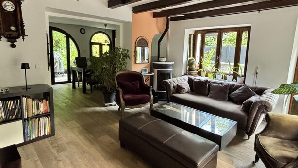 A cozy living room with a fireplace, a sofa, a chair, and a bookshelf. - Au moulin - GEX - Gîte (GEX)