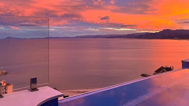 A coastal view with a sunset over the water, a clear sky, and distant mountains. - Beautiful home in Cullera (Cullera)