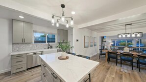 Una cocina amplia con una isla grande, piso de madera y vistas al exterior.