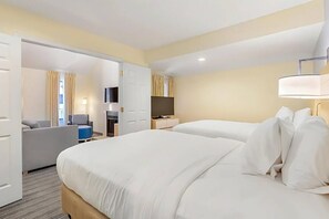 Een hotelkamer met twee bedden, een televisie, een bureau en een bank.
