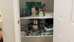 A kitchen with a white buffet burner, a green cutting board, and a box of Elite Gourmet electric double buffet burner. - Private Ground-Floor 2BR Suite in Gated Community - Near the Woodlands (Conroe)