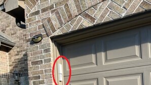 A garage door with a stone wall and a number '8321' on the left. - Private Ground-Floor 2BR Suite in Gated Community - Near the Woodlands (Conroe)