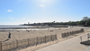 A beach with a wooden fence and a concrete walkway. - Cozy apartment in La Rochelle with WiFi (La Rochelle)