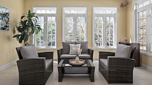 A living room with a sofa set, a coffee table, and a large plant.
