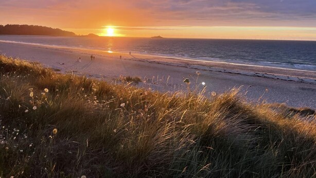 A beach with a sunset, grassy dunes, and a calm sea. - L'Estran - ERQUY - Gîte (ERQUY)