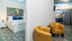 A bedroom with a bed, bedside table, and a painting on the wall.