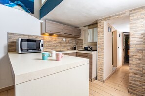 Eine moderne Küche mit Mikrowelle, Kaffeemaschine und zwei Tassen auf der Arbeitsfläche.