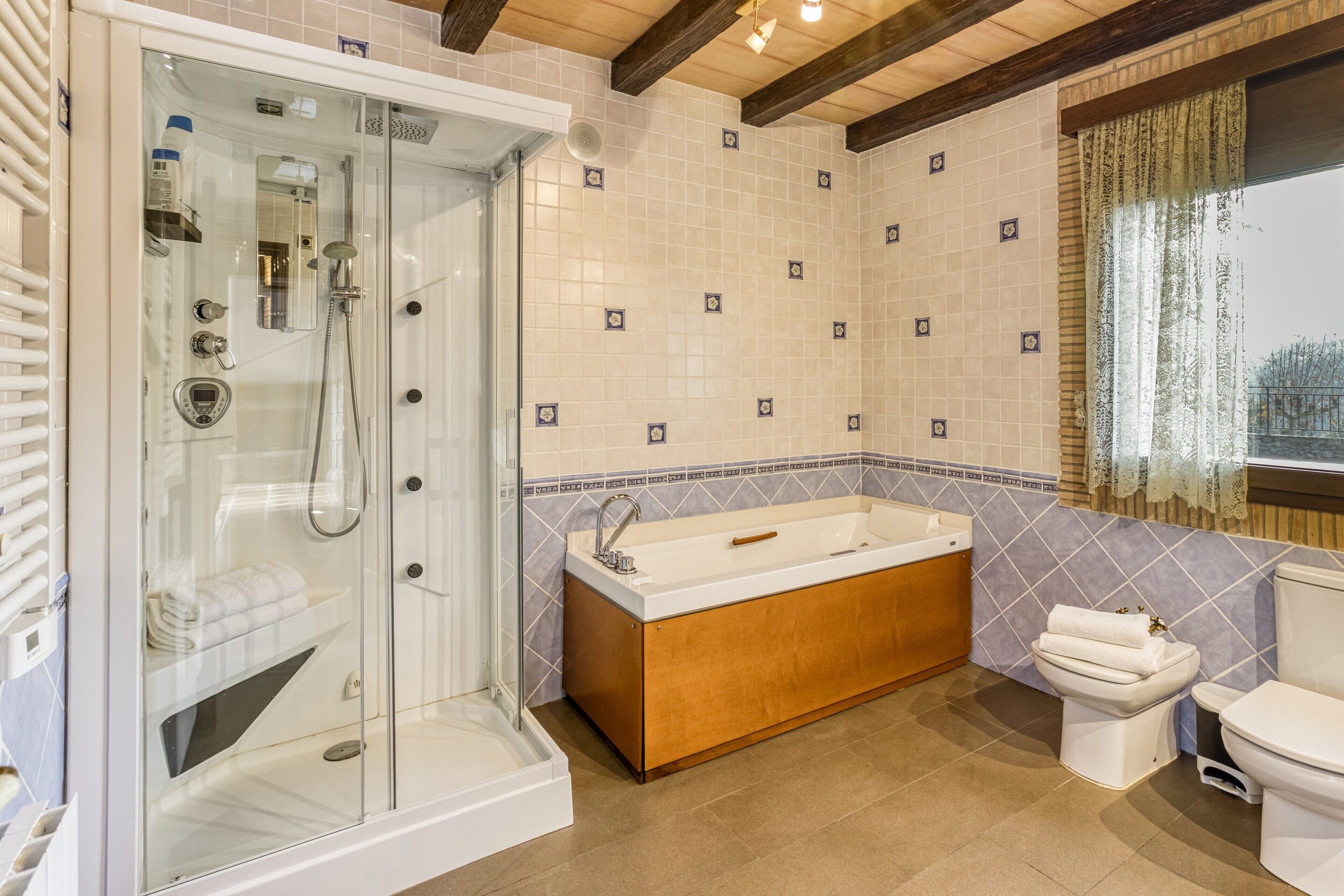 Un baño moderno con ducha envuelta en vidrio, bañera independiente, inodoro y lavamanos.