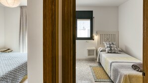 Quarto com cama, mesa de cabeceira e janela.
