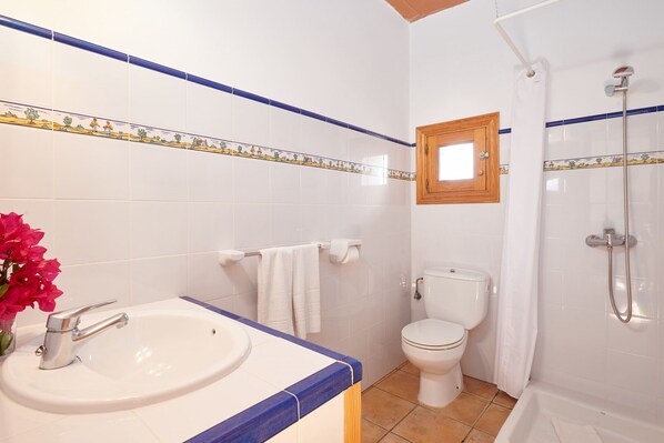 A bathroom with a sink, toilet, shower, and a small window. - Country House 'Magdalena - Son Gaya' with Private Pool, Wi-Fi and Air Conditioning (Illes Balears)