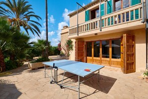 Una mesa de ping pong en un espacio exterior, con un edificio al fondo.