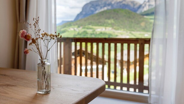 A clear view of a mountain landscape through a window with a wooden railing. - Apartment 'Hans' with Mountain View, Private Garden and Wi-Fi (Cornedo all'Isarco)