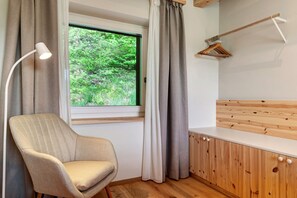 A room with a window, a chair, a wooden cabinet, and a hanging wooden hanger. - Apartment 'Hans' with Mountain View, Private Garden and Wi-Fi (Cornedo all'Isarco)