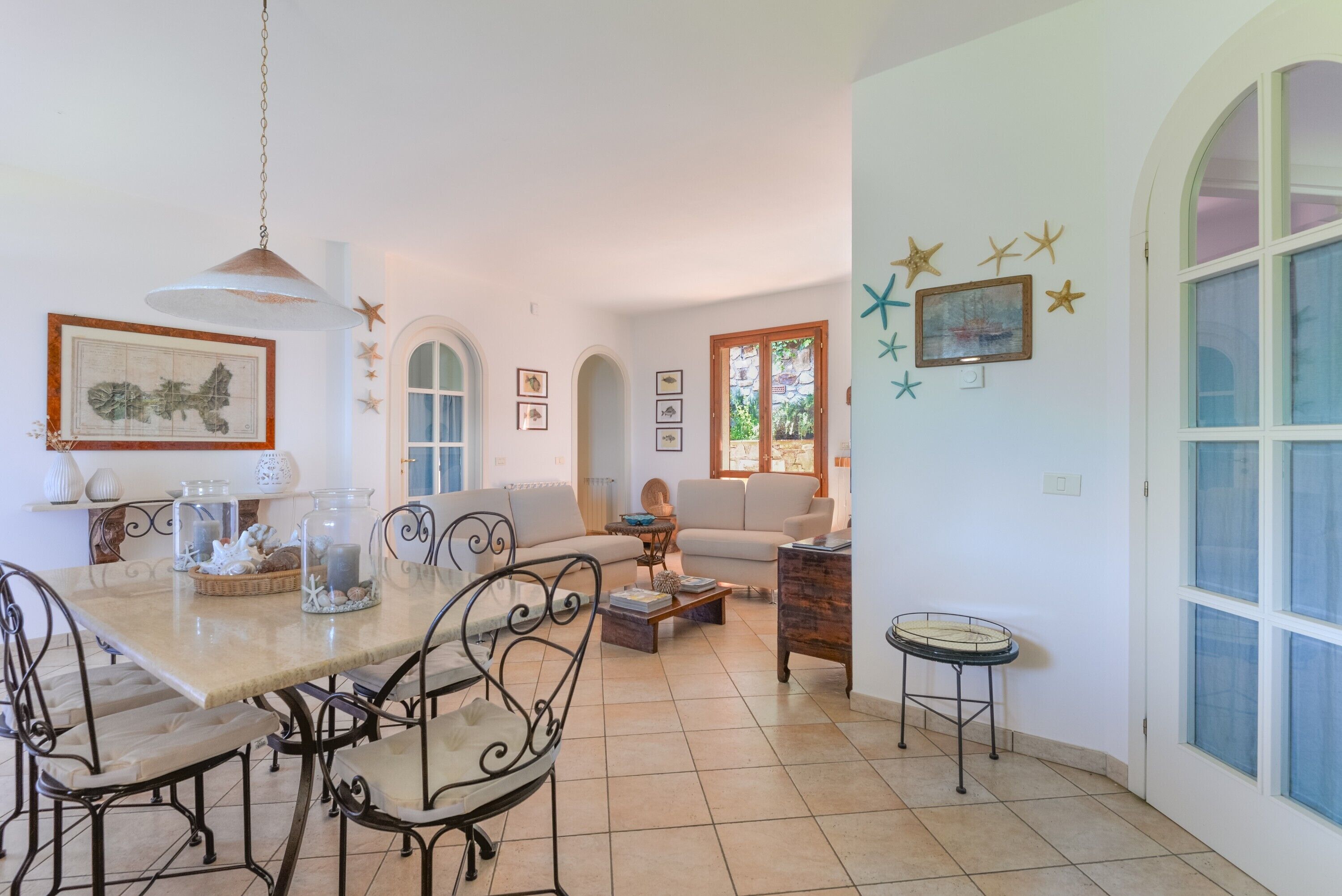 Un'ampia zona giorno con tavolo da pranzo, due divani e tavolino.