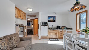 Un espacio habitable compacto con kitchenette, comedor y sofá.