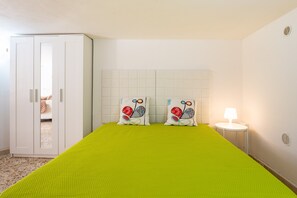 A room with a bed, a wardrobe, and a nightstand with a lamp. - Apartment 'Mi Casa Es Tu Casa - Cantina Giulia' with Private Terrace, Wi-Fi and Air Conditioning (Donnalucata)