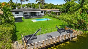 Ein modernes Haus mit Swimmingpool, Terrasse und üppigem Grün.