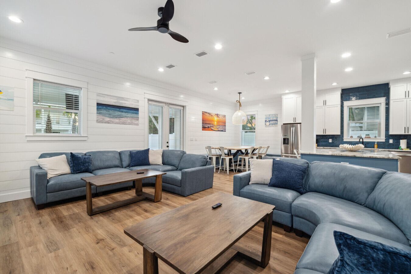 A modern living room with a grey sofa set, a wooden coffee table, and a ceiling fan.