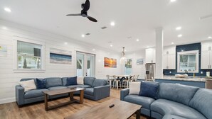 A modern living room with a grey sofa set, a wooden coffee table, and a ceiling fan.