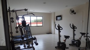 Uma academia com equipamentos de ginástica, esteira e elíptico.