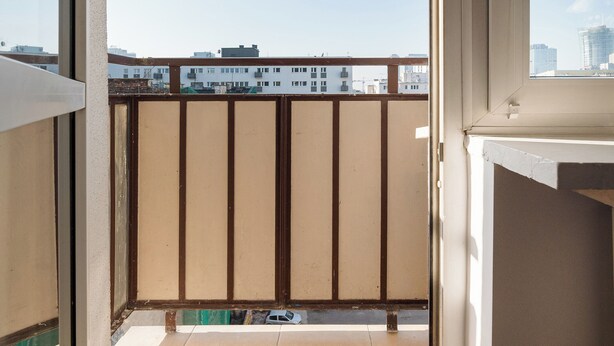 A balcony with a view of buildings and a clear sky. - Złota Standard Studio (Warszawa)