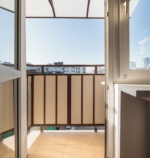 A balcony with a view of buildings and a clear sky.