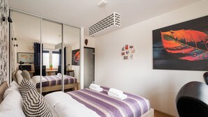A bedroom with a bed, a desk, a mirror, and a large window. - Marywilska 67 Inviting Apartment (Warszawa)