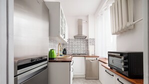 Eine kompakte Küche mit Einbauofen, Geschirrspüler und Toaster.