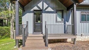 A wooden cabin with a porch, a door, and a window. - New Construction! 7 bedroom luxury lakefront  home in golf neighborhood! (Swanton)