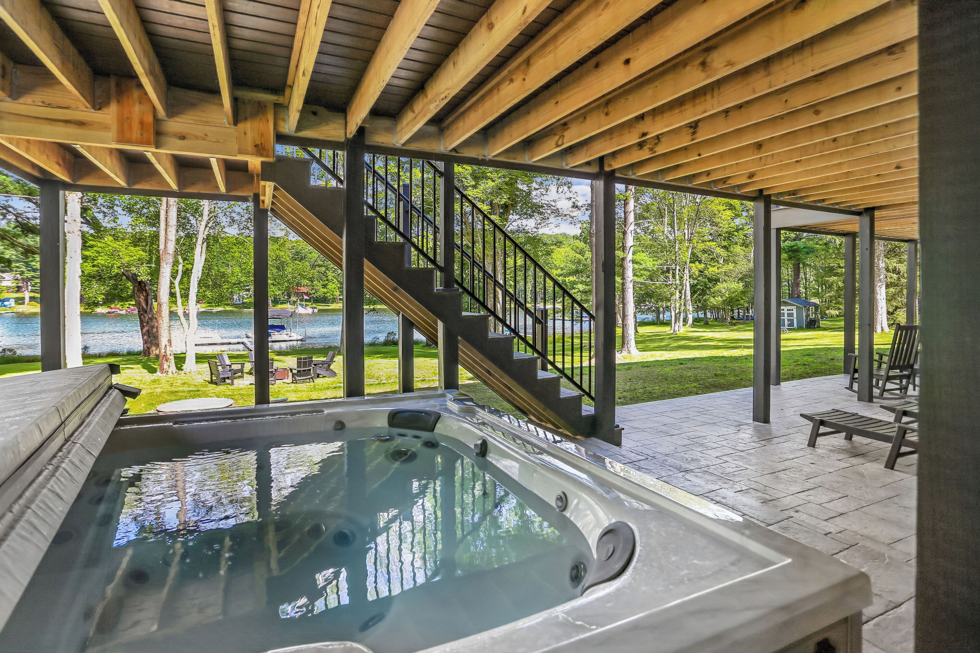 Zona de hidromasaje con una terraza de madera y una escalera que lleva a una terraza exterior.