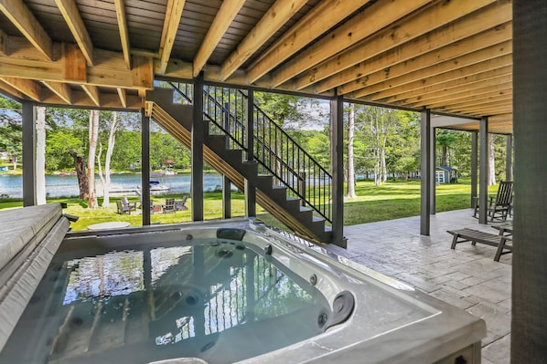 Zona de hidromasaje con una terraza de madera y una escalera que lleva a una terraza exterior.