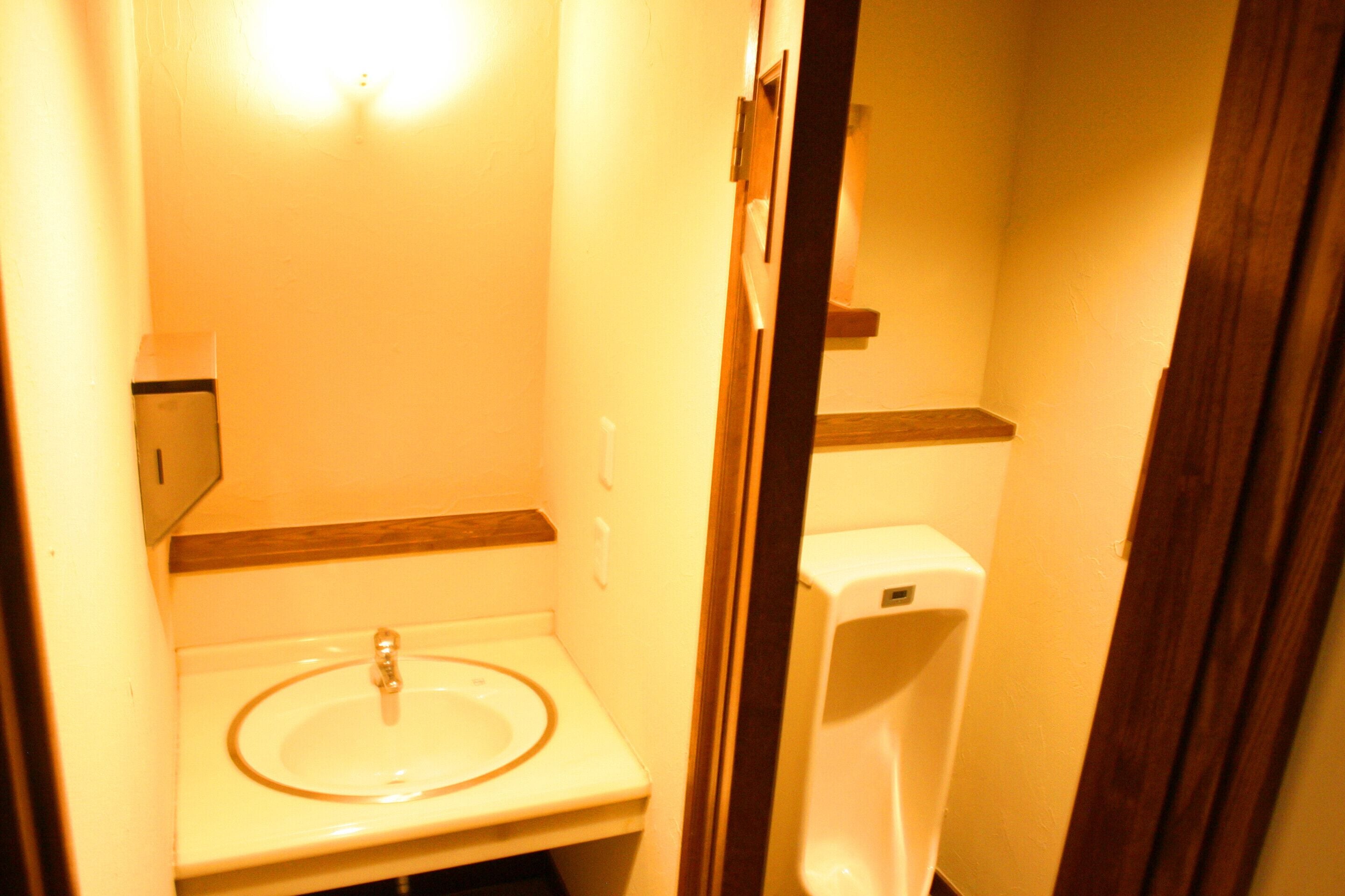 A small bathroom with a sink, a toilet, and a urinal.