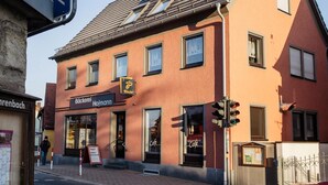 A two-story building with a café named "Böckerei Hofmann" on the ground floor. - Vacation apartment at Walberla (Kirchehrenbach)