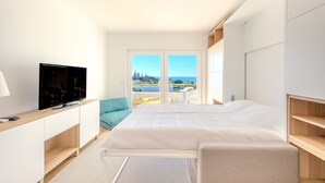 Un dormitorio moderno con una cama grande, un televisor y un balcón con vistas.