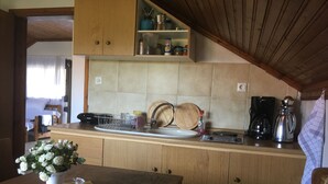 Eine Küche mit Holzausstattung, einer Arbeitsplatte mit Kaffeemaschine und einem Geschirrgestell.