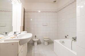 A bathroom with a sink, bidet, toilet, and bathtub. - Cozy and bright apartment of approximately 89 m2, able to accommodate up to 5 people, located on the first floor of a historic building (NO lift), partially renovated and with independent entrance.Located in a very central position, on Lido di Dongo, the (Dongo)