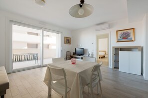 A modern apartment with a dining area, a TV, and a balcony. - GuestHost - Bright Apartment Affori, Milan (Milano)