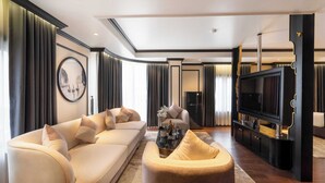 A modern living room with a beige sofa, a coffee table, and a TV on a black stand. - FTE Ha Long Hotel (Bai Chay)
