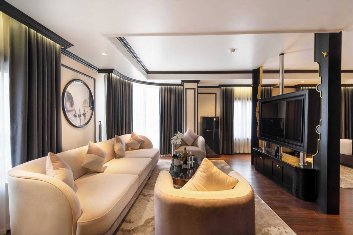 A modern living room with a beige sofa, a coffee table, and a TV on a black stand.